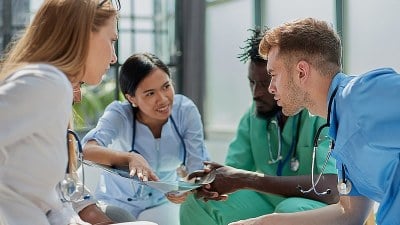 Four nurses sitting together and reviewing a document in a BSN to MSN nursing program