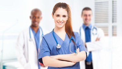 Three smiling nurses with arms crossed, standing together during a nursing preceptorship
