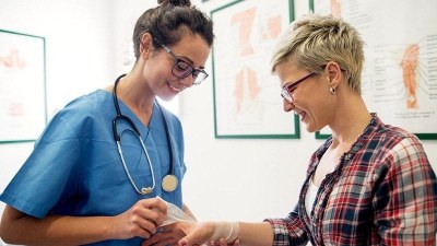 ABSN student in California practicing clinical skills with a patient in a medical training setting.