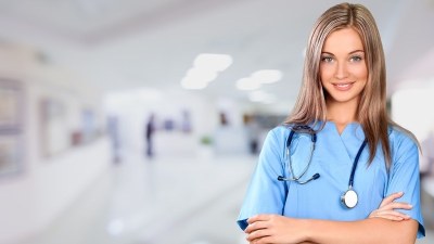 Nurse in scrubs standing in a hospital hallway, part of a guide to the best NP programs in Colorado.