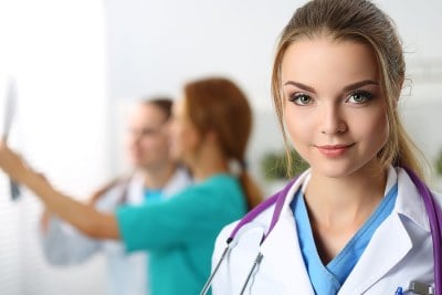 Nurse smiling while standing in a DNP program classroom in Illinois.