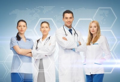 Healthcare professionals standing with their arms crossed enrolled in an MSN program in Arkansas.