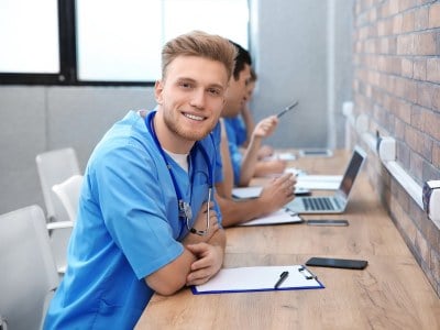 Student taking notes during training as part of an ADN program in Alabama.